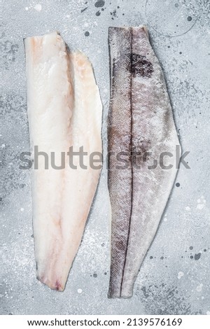 Two raw haddock fish fillets on kitchen table. Gray background. Top view. Foto d'archivio © 