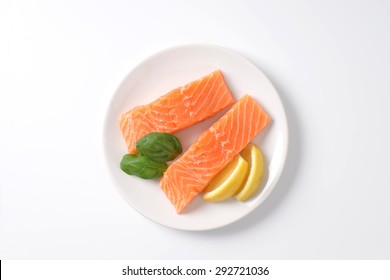 Two Raw Salmon Fillets On White Plate