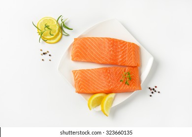 Two Raw Salmon Fillets On White Square Plate