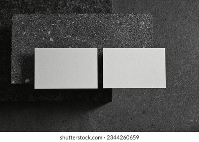 Two real white business cards on elegant dark concrete background, Empty template for luxury stationery mockup