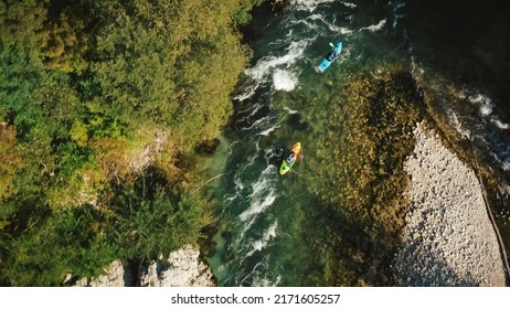 Two Recreational Athletes Kayaking Over Fast Moving Water, Paddling And Successfully Maneuvering Between River Rock Obstacles, Aerial Drone View.