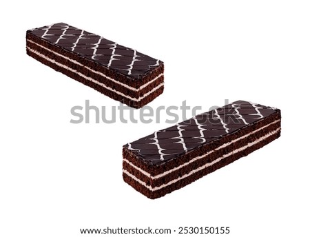 Two rectangular chocolate cake bars with layers are covered with chocolate icing and a white chocolate design on a white background