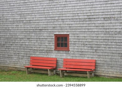 Two red benches against an older building  - Shutterstock ID 2394558899