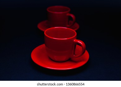 Two red cups of tea on the black table. Breakfast composition.