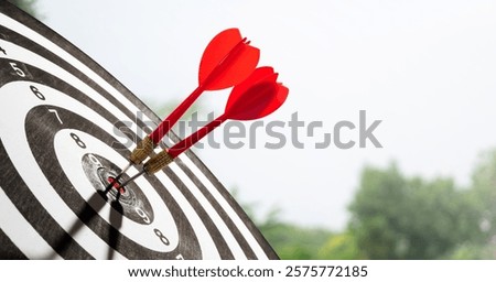 two red dart on target with sky and tree