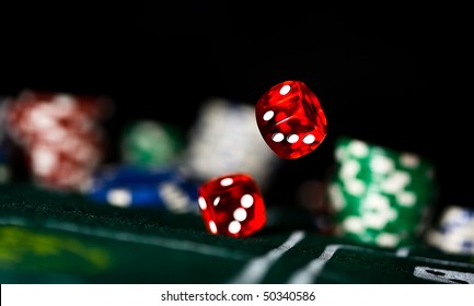 Two Red Dice Rolling On Felt