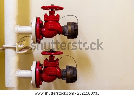 Two red fire hydrants with valves from the ship's fire suppression system, standing out vividly against a yellow wall. The safety equipment, a key feature aboard the vessel.