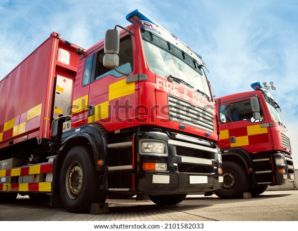 Two red fire truck emergency vehicles. The\
fire engines are with ladders, firefighting apparatus and water to\
save lives, suppress wildfire, extinguish building fires and assist\
vehicle collisions.