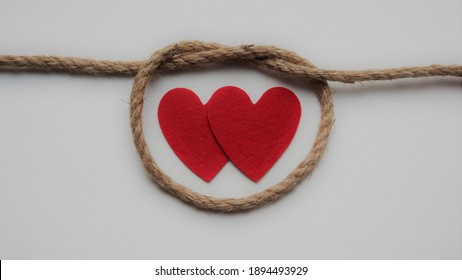 Two Red Hearts In A Knot Rope On White Background. Love. Union. Couple. Strong Relationship. Together. Abuse. Symbol. Addiction. Saint Valentine. 14 February. - 13 January 2021, Montreal, Canada 