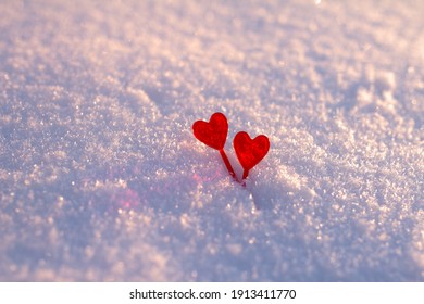 Two Red Hearts Sticks For Canapes In Snow At Sunset