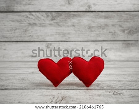 Two red hearts tightly sewn together. Valentine's Day background. The heart of love. Place for text