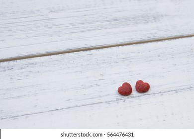 Two red little hearts on white wooden background with copy space