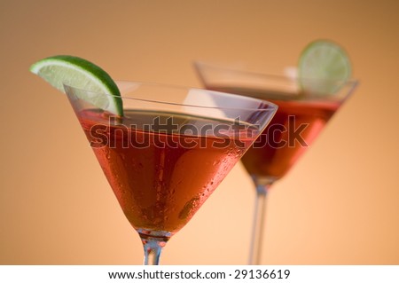 two red martinis with lime, focus is on front glass