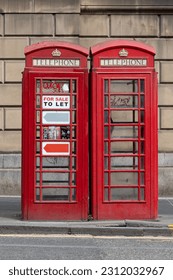 Two red old telephone cabine with posters - Shutterstock ID 2312032967