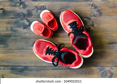 Two red sport running shoes or sneakers of mother or father and child on wooden background,use for father's day or mother's day or family's day with sport concept - Powered by Shutterstock