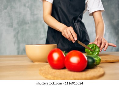 two red tomatoes on the table and a cook with a knife                            