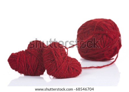 Two red woolen hearts connected in one knot