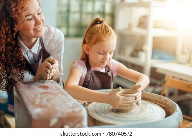 two redhead sisters make a pitcher of a pottery wheel - Powered by Shutterstock