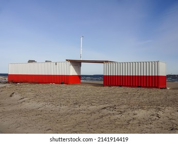 Two red-white containers on empty Pirita sandy beach in Pirita, Tallinn, Estonia, Europe before the season started. Blue sky. March 2022.