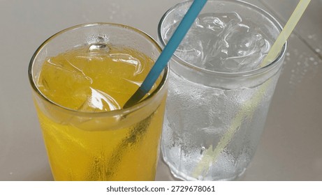 Two Refreshing Cold Drinks with Orange and Lychee Flavor on Table