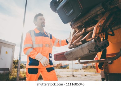 Two Refuse Collection Workers Loading Garbage Into Waste Truck Emptying Containers