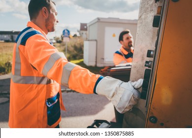 Two Refuse Collection Workers Loading Garbage Into Waste Truck Emptying Containers