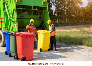 Two Refuse Collection Workers Loading Garbage For Trash Removal.