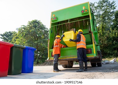 Two Refuse Collection Workers Loading Garbage For Trash Removal.