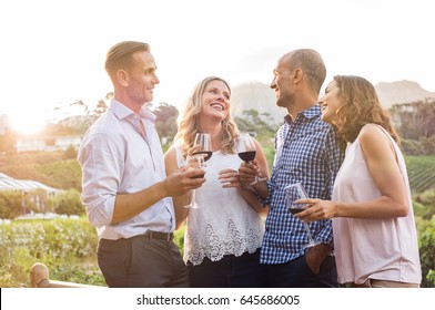 Two relaxed mature couples laughing and enjoy glasses of red wine at sunset. Group of happy friends celebrating outdoor and toasting with glassess. Happy man and smiling women having fun at vineyard.
 - Powered by Shutterstock