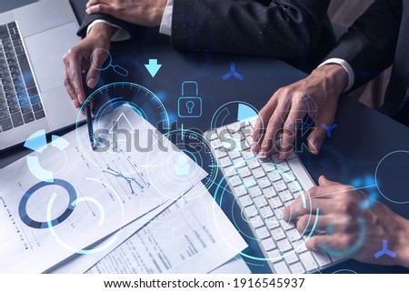 Two research and development specialists man and woman working on project to create a new approach to develop software to improve business. Technological icons over the table with document.