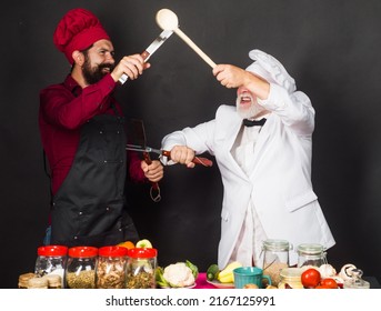 Two Restaurant Chefs Or Bakers In Uniform Fighting In Kitchen. Cooking Food. Competition Of Chef.