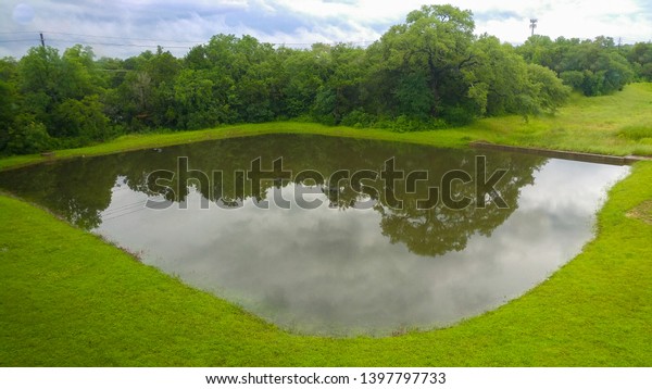 two retention ponds full of water with the\
dividing wall completely\
submerged