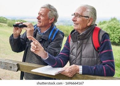 Two Retired Male Friends On Walking Holiday Looking Through Binoculars               - Powered by Shutterstock