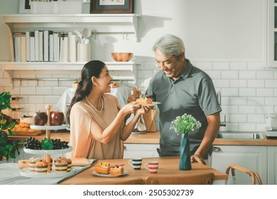 Two retired senior couples are tasting food they cooked together and laughing and chatting happily. Concept of health, retirement insurance, wealth accumulation, retirement society. - Powered by Shutterstock