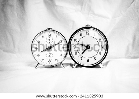 Two retro alarm clocks in black and white on white background