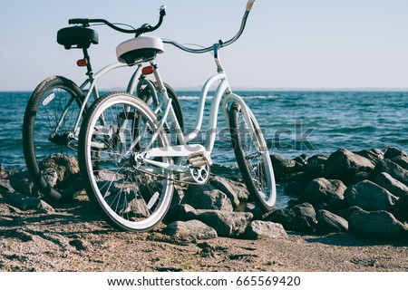Two retro bike on the beach against the blue sea on a sunny day