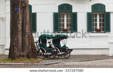 Two retro cyclo parking in front of a five stars French architecture in Hanoi, Vietnam.