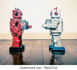 Two Retro Robots Face Off With Ray Guns On A Wooden Floor With Reflection 