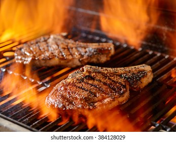 Two Ribeye Steaks Grilling On The Open Flame