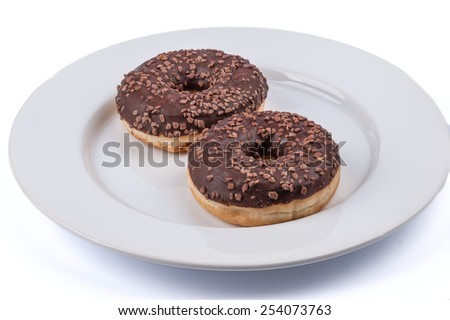 Two ring donuts with chololate glaze on white plate
