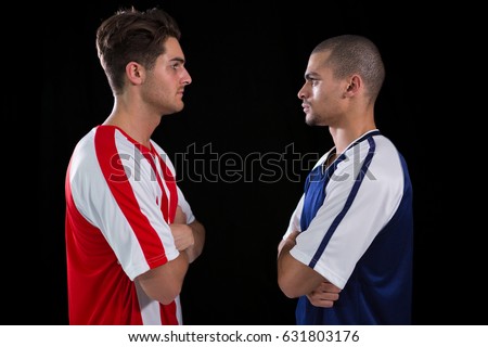 Two rival football player looking at each other against white background