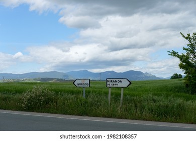 Two road signs each with an arrow pointing in the direction opposite the other. Cloudy day. Landscape.  - Powered by Shutterstock