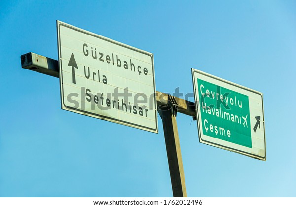 Two road signs which shows different\
directions on a blue sky background at Narlidere road, in\
Narlıdere, in Izmir,in Turkey – June 20,\
2020