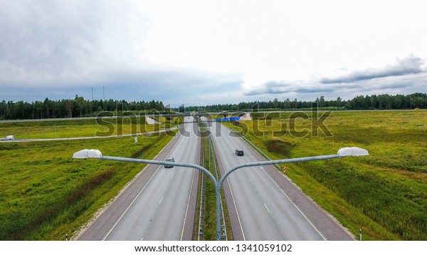 Two roads with the lamp post on\
an aerial shot on both sides of the road are the agri\
field