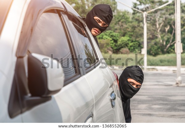 Two robbers are secretly behind the car. Planning\
a robbery