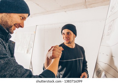 Two Robbery Men Prepare For A Bank Robbery On Map In A Garage