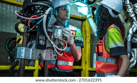 Two robotics engineers in an R and D lab perform diagnostics on an artificial intelligence robot. They are inspecting the complex hardware, wiring, and high tech sensors.