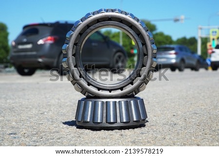 Two roller bearings are installed on the road against the background of cars. Automotive and engineering concept.                       