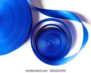 Two Rolls Of Thick And Curly Blue Satin Ribbon Isolated On A White Background. Coarse Textured Ribbon. 