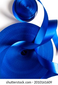 Two Rolls Of Thick And Curly Blue Satin Ribbon Isolated On A White Background. Coarse Textured Ribbon. 